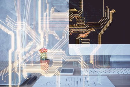 Computer on desktop in office with technology theme hologram. Double exposure. Tech concept.の写真素材