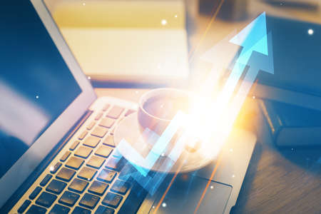 Computer on desktop with point up arrows hologram. Double exposure. Concept of success.の写真素材