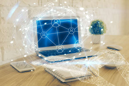 Computer on desktop with social network hologram. Multi exposure. Concept of international people connections.の写真素材