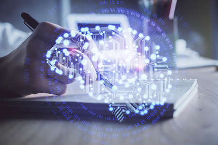 Multi exposure of writing hand on background with brain hologram. Concept of self learning.
