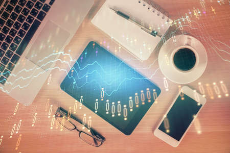 Double exposure of financial graph hologram over desktop with phone. Top view. Mobile trade platform...