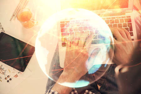 Double exposure of mans hands typing over computer keyboard and business theme hologram drawing. Top view. Financial markets concept.の写真素材