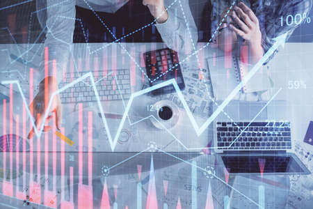 Double exposure of man and woman working together and financial graph hologram drawing. market...