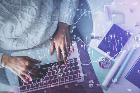 Multi exposure of woman hands working on computer and forex chart hologram drawing. Top View....