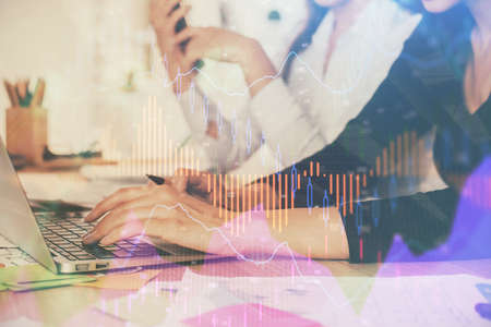 Multi exposure of woman hands typing on computer and financial graph hologram drawing. Stock market...
