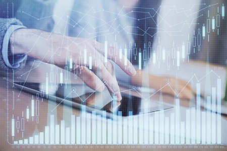 Double exposure of forex graph drawing and man and woman working together holding and using a mobile...