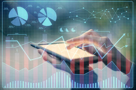 Double exposure of forex chart sketch hologram and woman holding and using a mobile device....