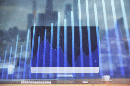 Stock market graph on background with desk and personal computer. Multi exposure. Concept of financial analysis.の写真素材