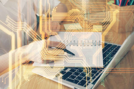 Tech theme hologram over womans hands taking notes background. Concept of hightech. Double exposureの写真素材