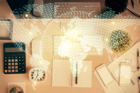 Business theme hologram drawings over computer on the desktop background. Top view. Multi exposure....