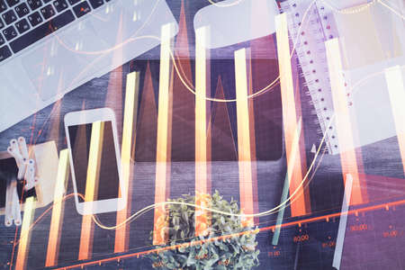 Double exposure of forex chart hologram over desktop with phone. Top view. Mobile trade platform...