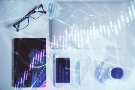 Multi exposure of financial chart hologram over desktop with phone. Top view. Mobile trade platform...