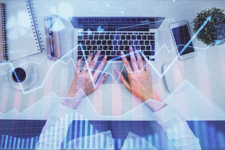 Double exposure of woman hands working on computer and forex chart hologram drawing. Top View....