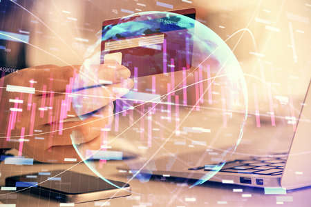 Multi exposure of woman on-line shopping holding a credit card and financial graph drawing. Stock...