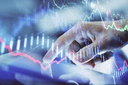 Multi exposure of mans hands holding and using a digital phone and forex graph drawing. Financial...