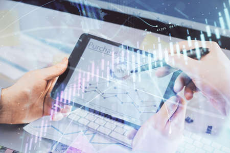 Double exposure of mans hands holding and using a phone and financial chart drawing. Market analysis...