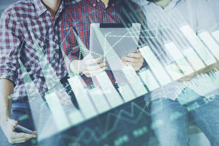 Double exposure of forex graph drawing and man and woman working together holding and using a mobile...
