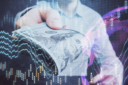 Multi exposure of financial graph drawing hologram and USA dollars bills and man hands. Analysis...