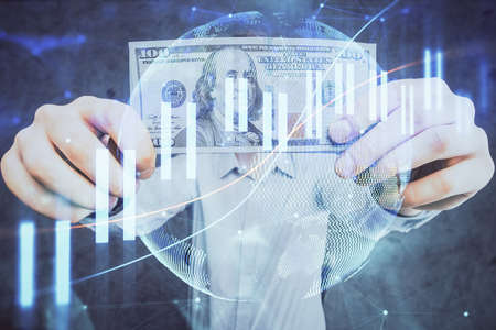 Multi exposure of financial graph drawing hologram and USA dollars bills and man hands. Analysis...