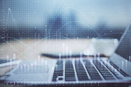 Financial chart drawing and table with computer on background. Multi exposure. Concept of...