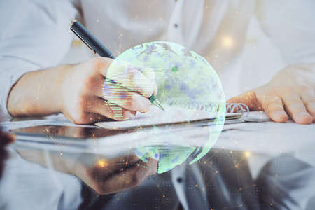 Mans hands working with notes background. Social networking concept. Crowd sourcing. Global business. Multi exposure.の写真素材