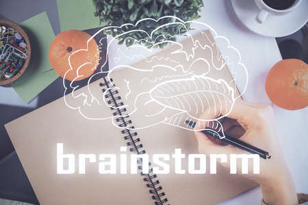 Start up creative drawing over close up hands in notepad background. Concept of brainstorming....