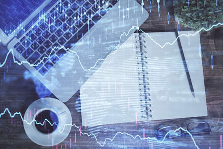 Financial market graph and top view computer on the desktop background. Double exposure. Investment...