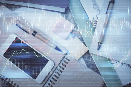 Multi exposure of forex graph hologram over desktop with phone. Top view. Mobile trade platform...