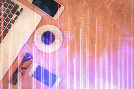 Double exposure of forex chart hologram over desktop with phone. Top view. Mobile trade platform...