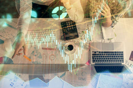 Double exposure of man and woman working together and financial chart hologram drawing. market...