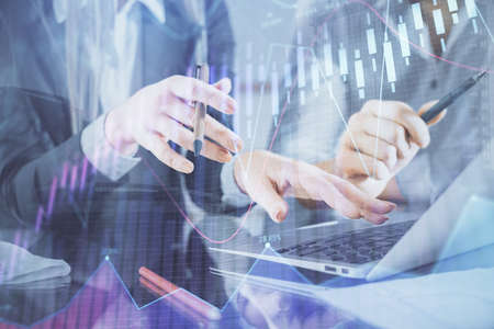 Multi exposure of man and woman working together and financial chart hologram. Business concept....