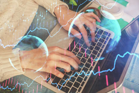 Double exposure of woman hands typing on computer and forex chart hologram drawing. Stock market...