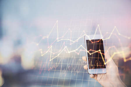 Double exposure of forex chart sketch hologram and woman holding and using a mobile device. Stock market concept.の写真素材