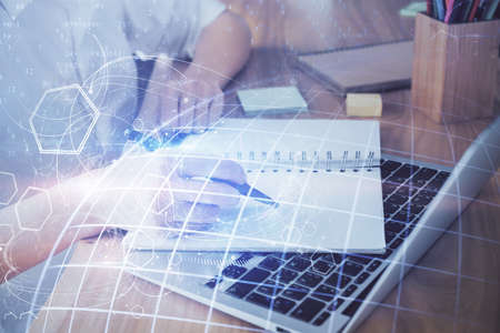 Double exposure of hands making notes with world map hologram and data theme icons. Concept of international network data.の写真素材