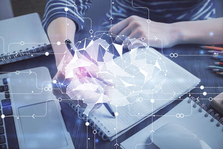 Multi exposure of writing hand on background with brain hologram. Concept of self learning.