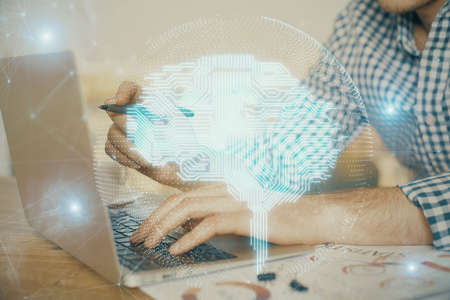 Man typing on keyboard background with brain hologram. Concept of big Data.の写真素材