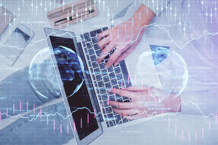 Double exposure of woman hands working on computer and forex graph hologram drawing. Top View....