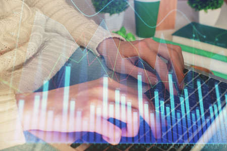 Double exposure of woman hands typing on computer and forex chart hologram drawing. Stock market...