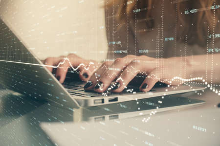 Double exposure of woman hands typing on computer and forex chart hologram drawing. Stock market...