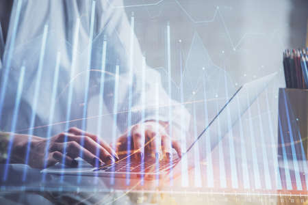 Double exposure of woman hands typing on computer and forex chart hologram drawing. Stock market invest concept.の写真素材