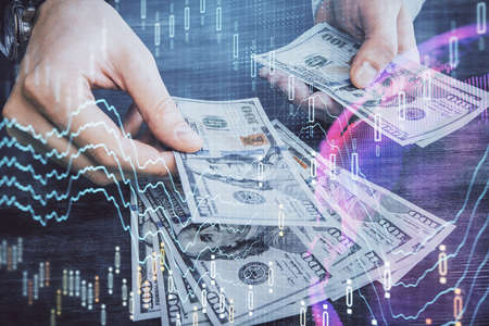 Multi exposure of financial graph drawing hologram and USA dollars bills and man hands. Analysis...