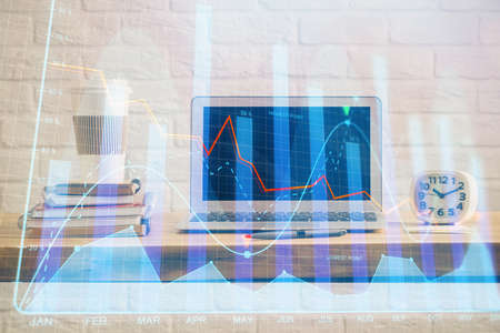 Financial market graph hologram and personal computer on background. Double exposure. Concept of forex.の写真素材