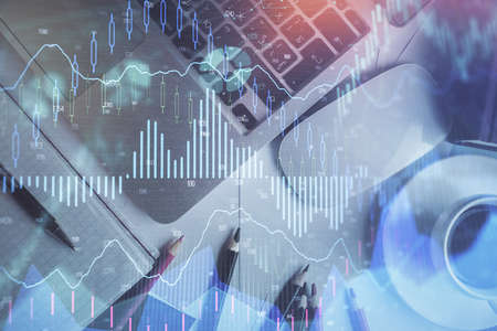 Double exposure of financial chart drawing over table background with computer. Concept of research...