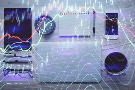 Double exposure of forex graph hologram over desktop with phone. Top view. Mobile trade platform...