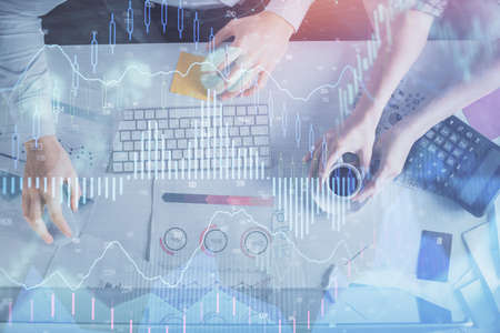 Double exposure of man and woman working together and financial chart hologram drawing. market...
