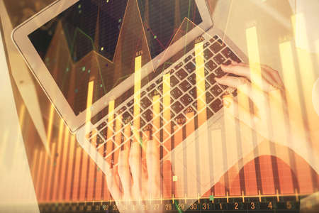 Double exposure of woman hands working on computer and forex chart hologram drawing. Top View....