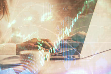 Double exposure of woman hands working on computer and forex graph hologram drawing. Financial...