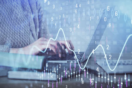 Double exposure of woman hands typing on computer and forex chart hologram drawing. Stock market...