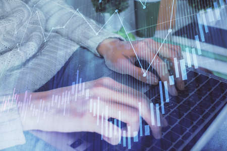 Double exposure of woman hands typing on computer and forex chart hologram drawing. Stock market...