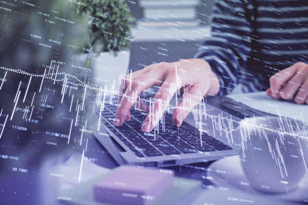 Double exposure of woman hands typing on computer and forex chart hologram drawing. Stock market...